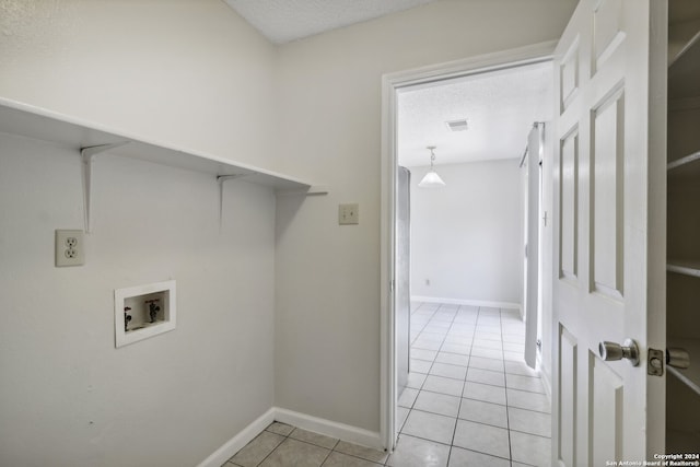 laundry room featuring hookup for a washing machine, light tile patterned flooring, and a textured ceiling