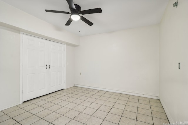 unfurnished bedroom with ceiling fan, a closet, and light tile patterned floors