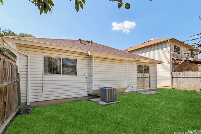 back of house featuring cooling unit and a yard