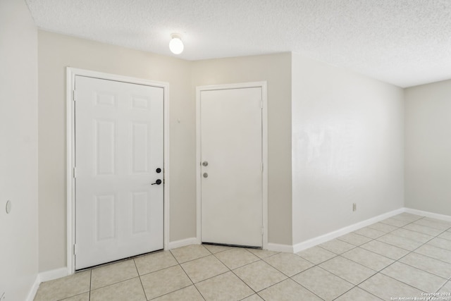 tiled foyer featuring a textured ceiling