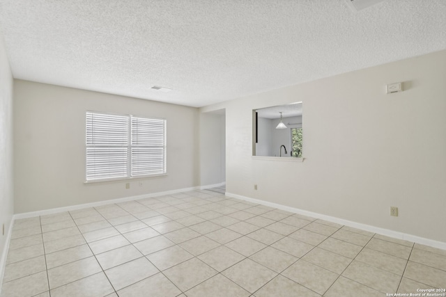 tiled spare room with a textured ceiling