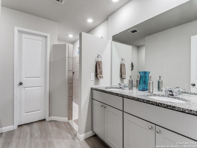 bathroom featuring hardwood / wood-style floors, a shower, and vanity