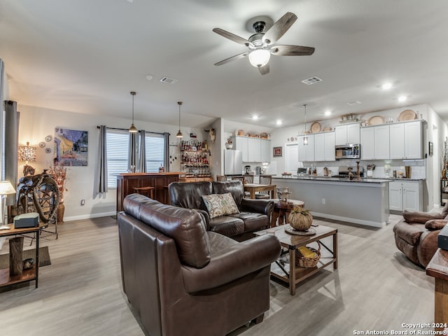 living room with light wood-type flooring and ceiling fan