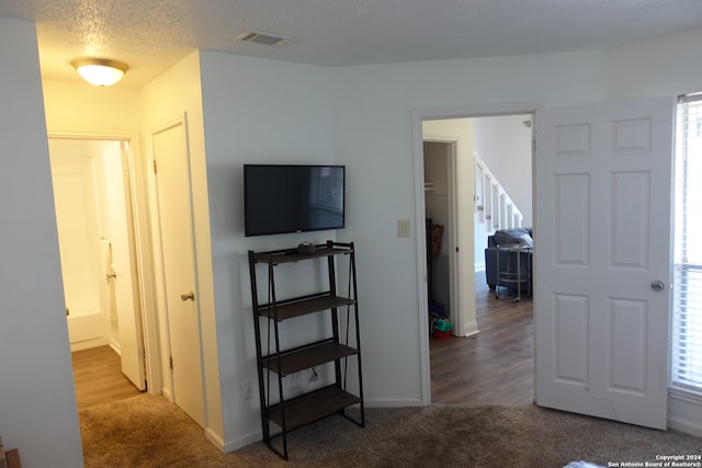 interior space with a textured ceiling and hardwood / wood-style floors