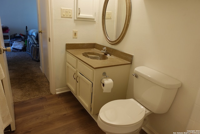 bathroom featuring vanity, hardwood / wood-style floors, and toilet