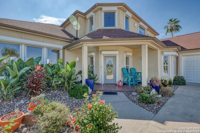 view of exterior entry with a porch and a garage