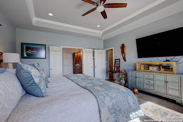 bedroom with ceiling fan, ornamental molding, a tray ceiling, and tile patterned flooring