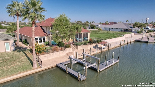 view of dock featuring a lawn and a water view