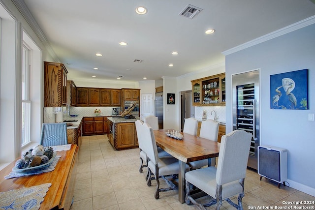 dining area featuring crown molding and light tile patterned flooring