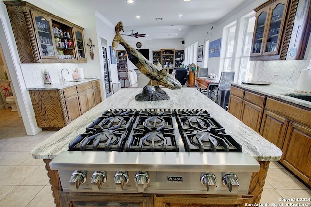 kitchen with light stone counters, a center island, light tile patterned floors, and decorative backsplash