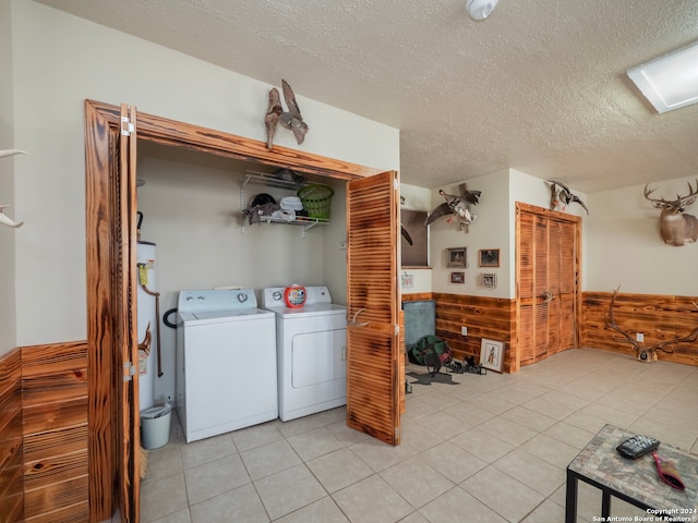 laundry room with light tile patterned floors, washer and clothes dryer, and a textured ceiling