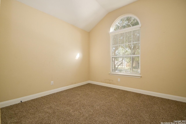 carpeted empty room with lofted ceiling