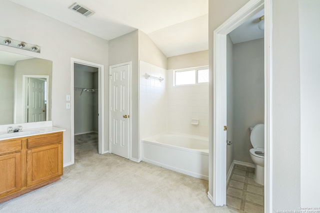 bathroom with vaulted ceiling, vanity, and toilet