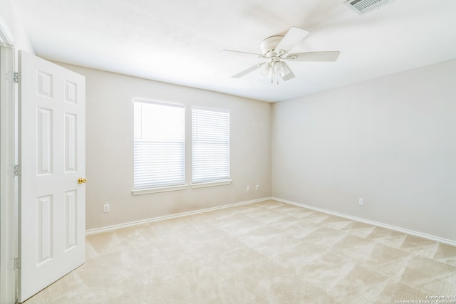 carpeted spare room featuring ceiling fan