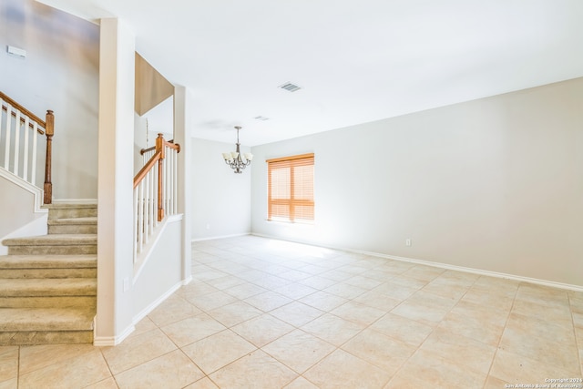 tiled empty room with a chandelier