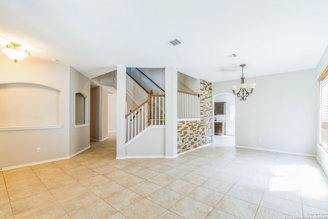 tiled empty room with a chandelier