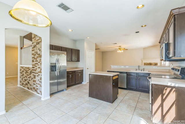 kitchen with a kitchen island, stainless steel appliances, dark brown cabinets, ceiling fan, and sink