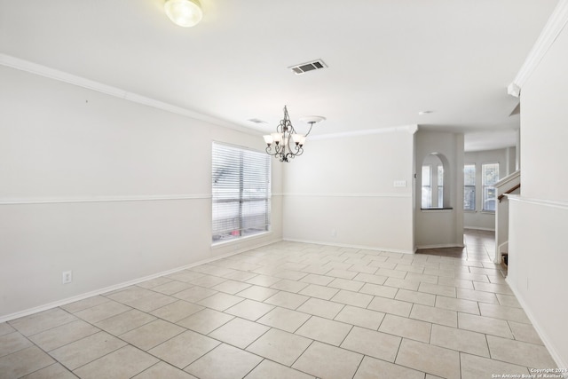 tiled spare room with crown molding and a chandelier