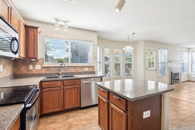 kitchen featuring appliances with stainless steel finishes, plenty of natural light, hanging light fixtures, and sink