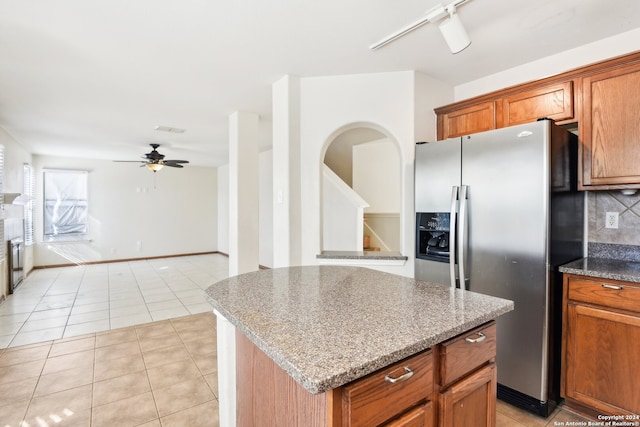 kitchen with ceiling fan, light tile patterned floors, track lighting, stainless steel refrigerator with ice dispenser, and a center island