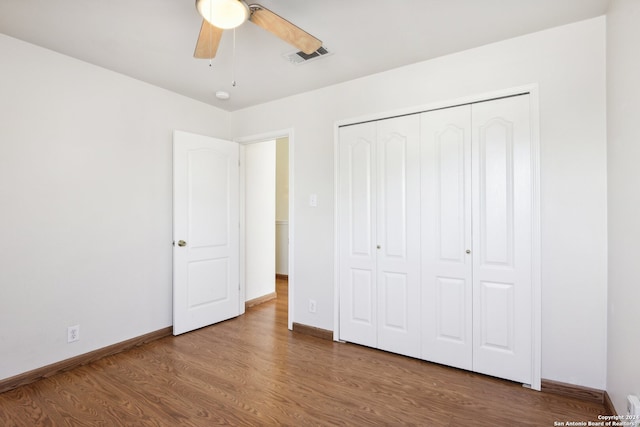 unfurnished bedroom featuring ceiling fan, hardwood / wood-style flooring, and a closet