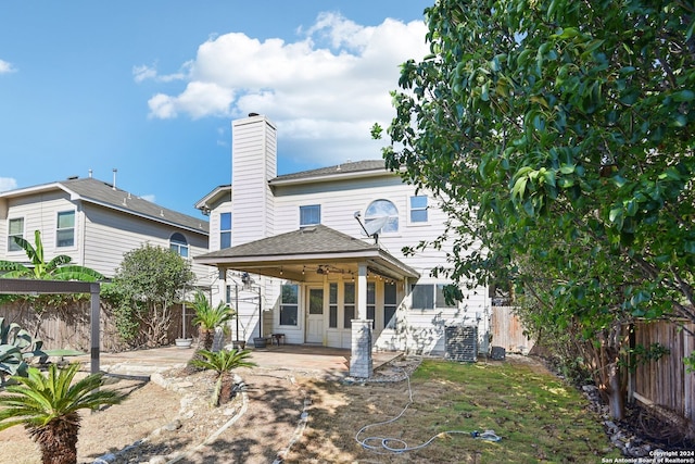 rear view of house featuring ceiling fan and a patio area