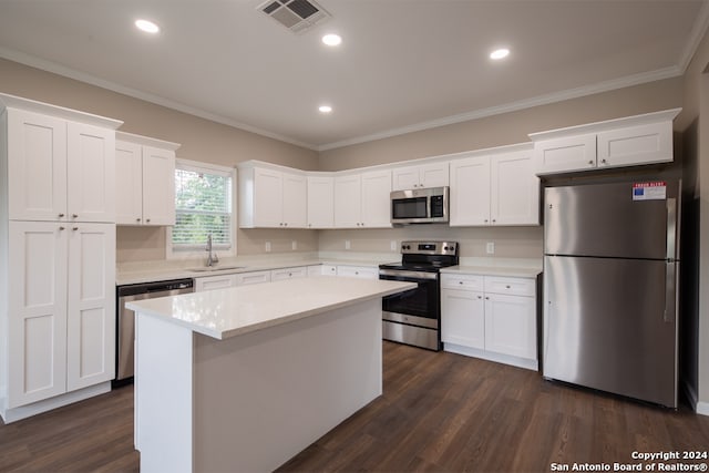 kitchen with white cabinets, a kitchen island, stainless steel appliances, dark hardwood / wood-style floors, and sink