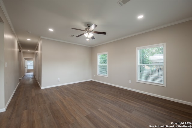 empty room with ceiling fan, dark wood-type flooring, and crown molding