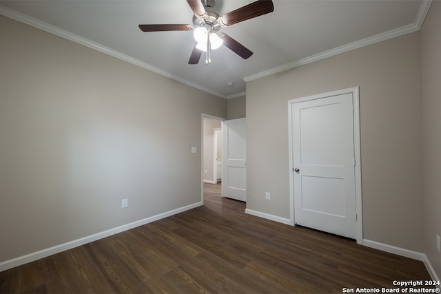 unfurnished bedroom with crown molding, dark hardwood / wood-style floors, and ceiling fan