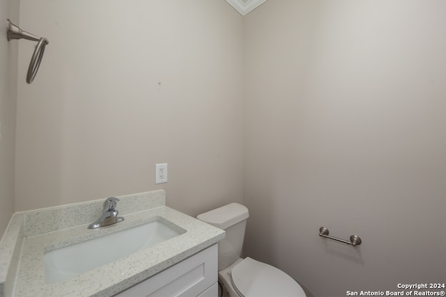 bathroom with vanity, crown molding, and toilet