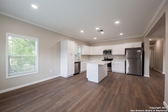 kitchen featuring ornamental molding, stainless steel appliances, white cabinetry, and dark wood-type flooring