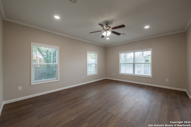 spare room featuring a wealth of natural light, ceiling fan, dark wood-type flooring, and crown molding