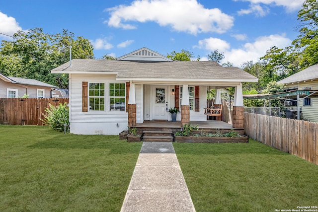 bungalow-style house with a front lawn and covered porch