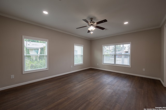 empty room featuring ceiling fan, dark hardwood / wood-style floors, crown molding, and a wealth of natural light