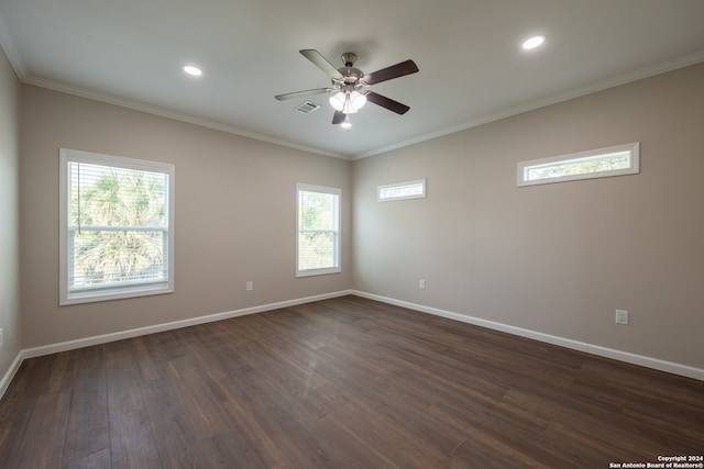 unfurnished room with a healthy amount of sunlight, ornamental molding, ceiling fan, and dark wood-type flooring