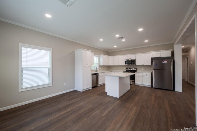 219 Gray St, San Antonio, TX 78208 - kitchen featuring dark wood-type flooring, light countertops, appliances with stainless steel finishes, and crown molding