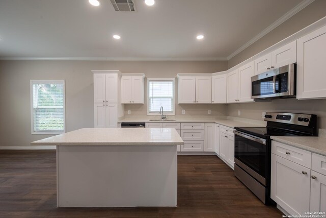 219 Gray St, San Antonio, TX 78208 - kitchen with crown molding, a center island, a sink, stainless steel appliances, and visible vents