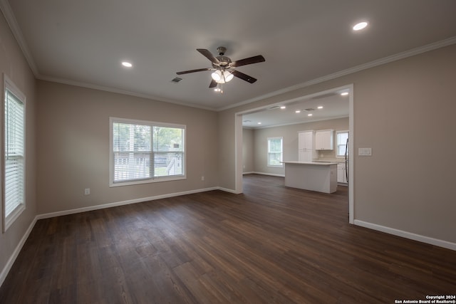 unfurnished living room with dark hardwood / wood-style floors, crown molding, and a wealth of natural light