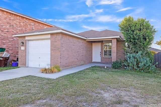 single story home featuring a front lawn and a garage