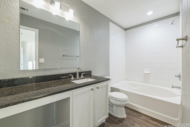 full bathroom with hardwood / wood-style flooring, vanity, toilet, and tiled shower / bath