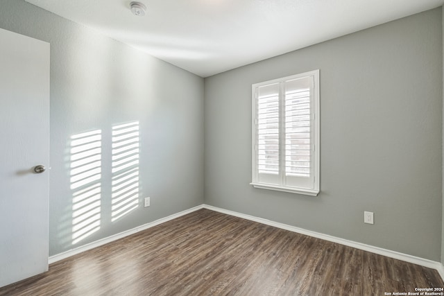 unfurnished room with dark wood-type flooring