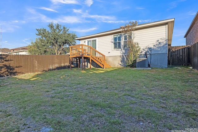 rear view of property with a lawn and central AC