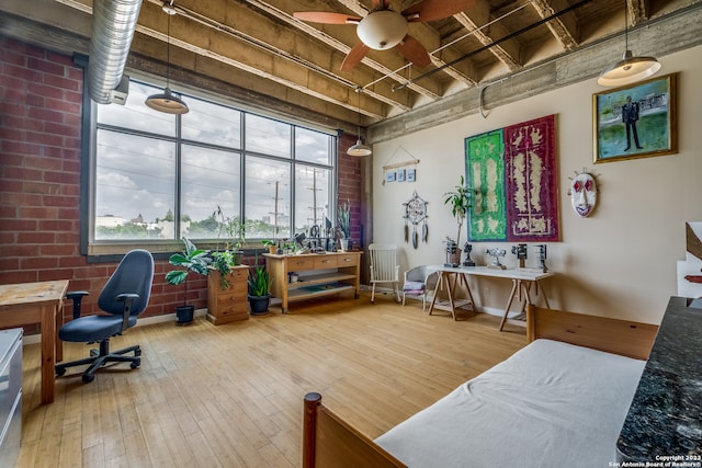 interior space featuring hardwood / wood-style floors, ceiling fan, and brick wall