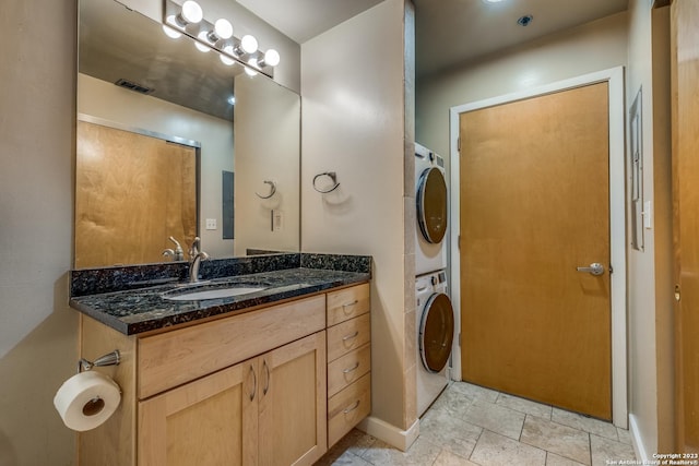 1331 S Flores St Unit 213, San Antonio, TX 78204 - bathroom featuring baseboards, vanity, and stacked washing maching and dryer