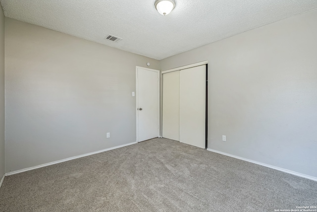 unfurnished bedroom with a closet, carpet flooring, and a textured ceiling