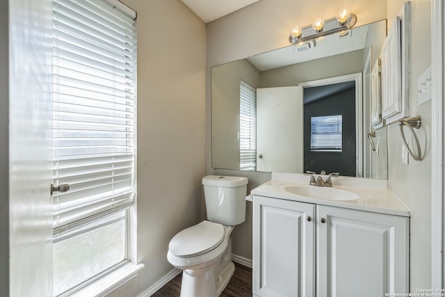 bathroom featuring wood-type flooring, vanity, and toilet