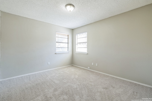 carpeted spare room with a textured ceiling