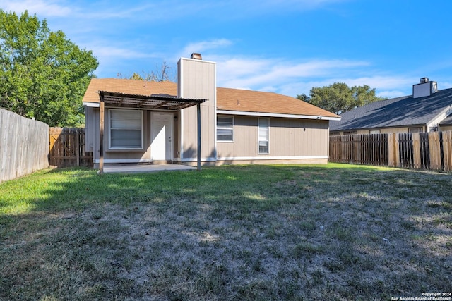 back of house with a pergola and a yard