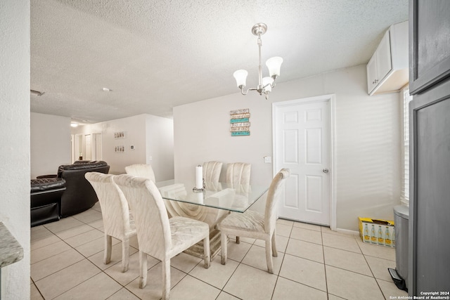 tiled dining room featuring a textured ceiling and a notable chandelier