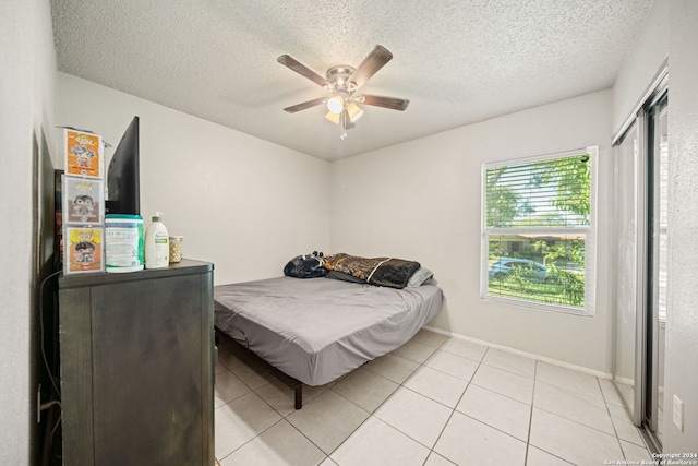 tiled bedroom featuring ceiling fan and a textured ceiling